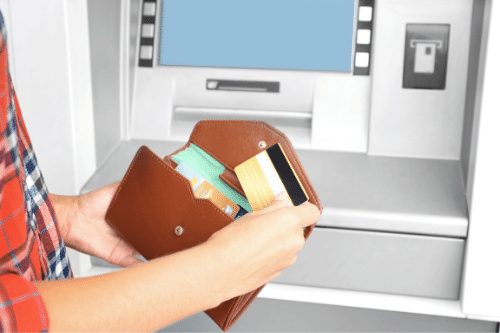 Person pulling card out of wallet to use at ATM